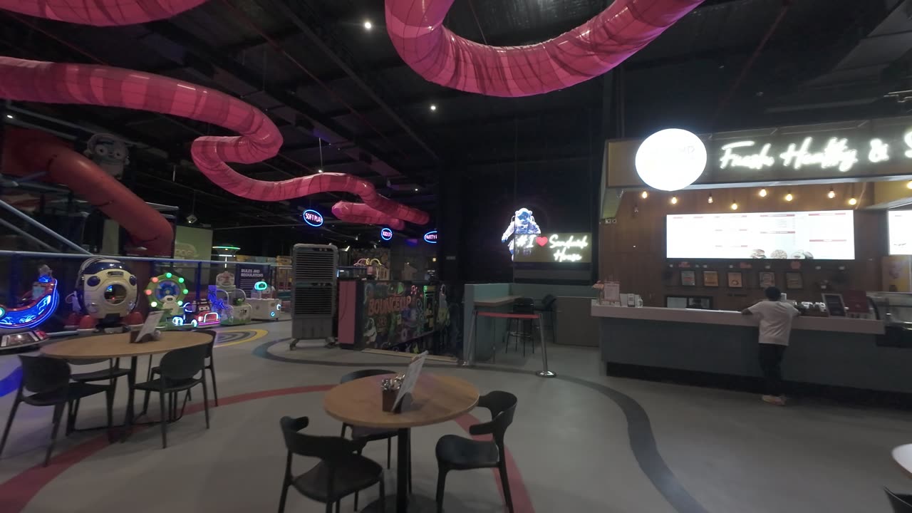 The café tables with the pink tube slide winding overhead